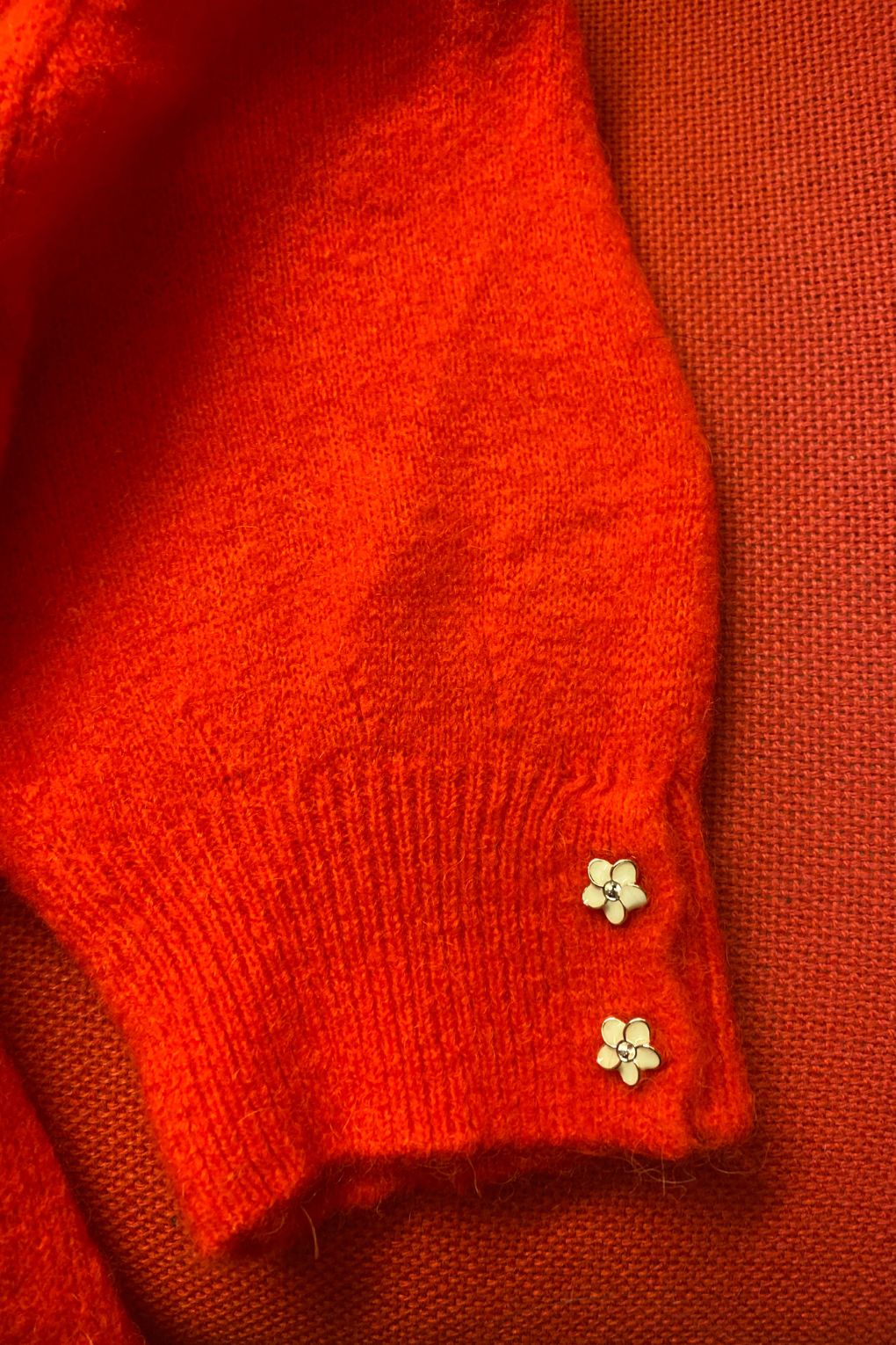 orange-red flower button knit close up